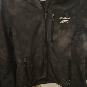Black and white acid wash Reebok jacket. Three front zippers. Adjustable hood.